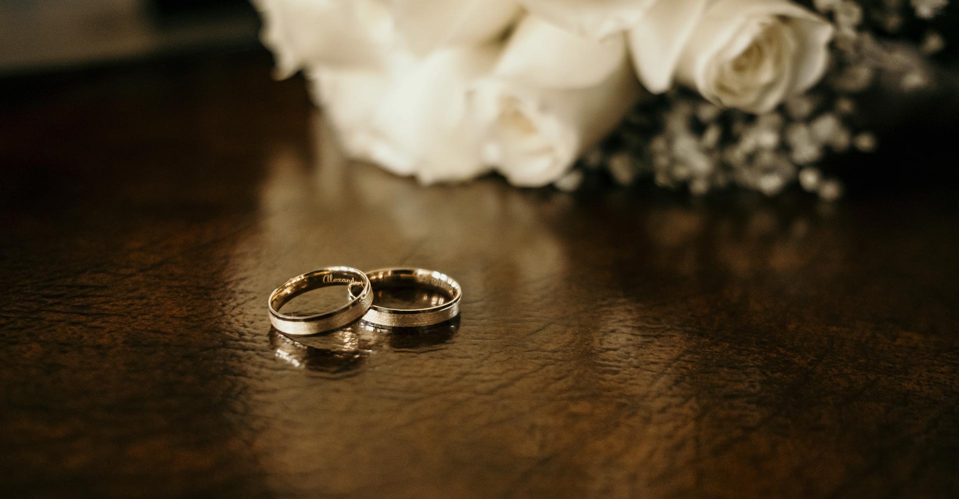 Anillos de boda con ramo de novia de fondo