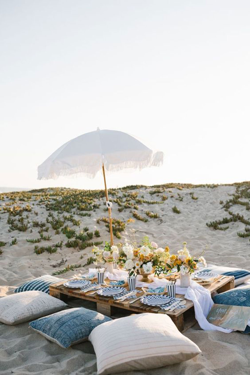 Picnic on the beach with umbrella and teepee